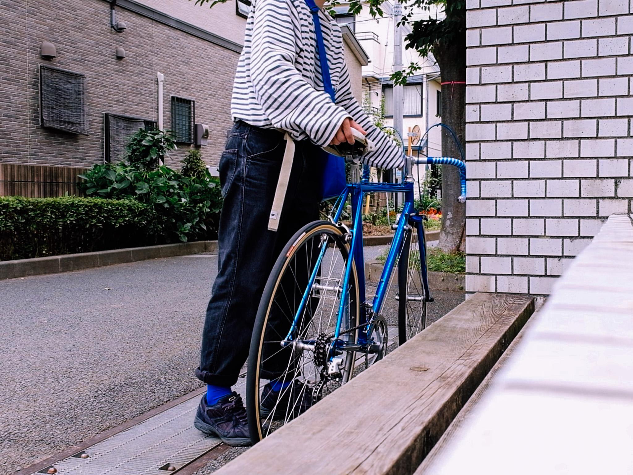 街角でNOICYCLE 001 METALLIC BLUE STRIPESを押す人を写した写真